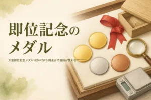 無地の金色のメダルとルーペ・はかりのイメージ、「即位記念のメダル」の文字